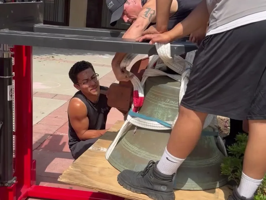 Rigging a heavy bronze bell onto a lift