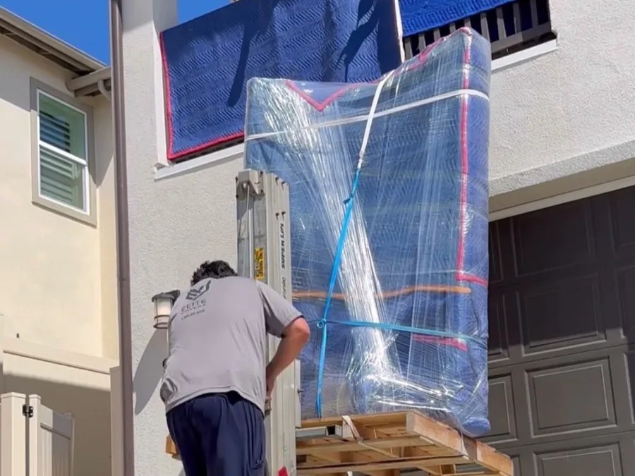 A wrapped piano on a lift at a balcony