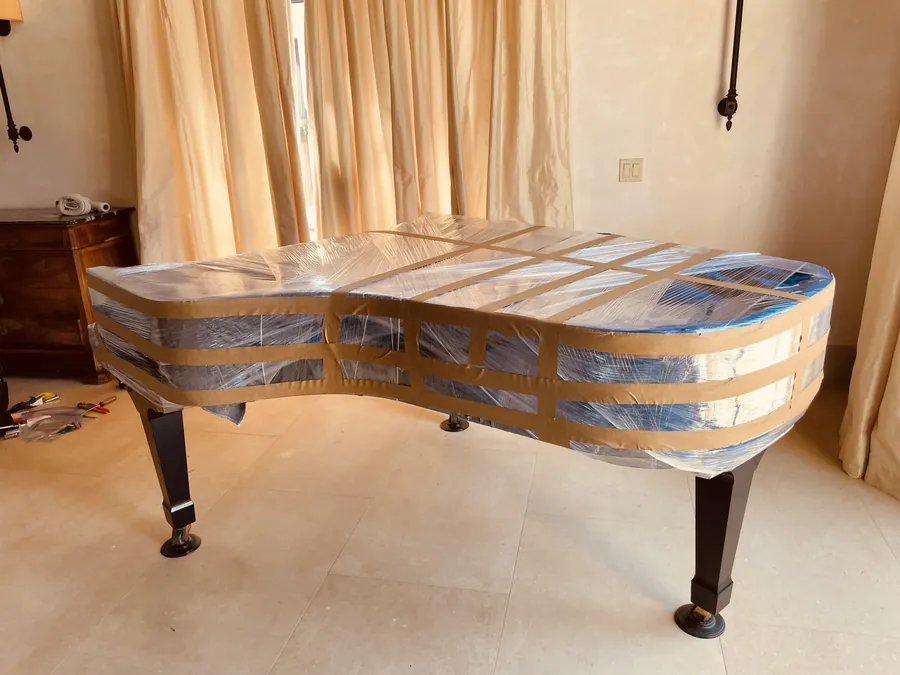 A grand piano fully padded and wrapped
